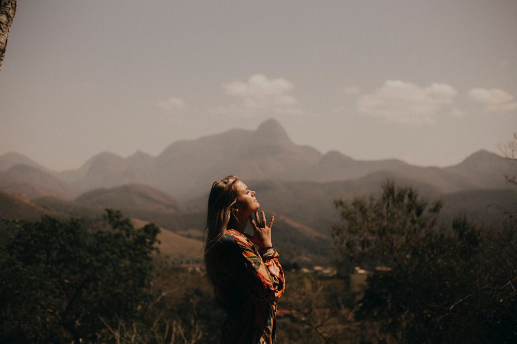 Women praying in front of mountains for emotional healing