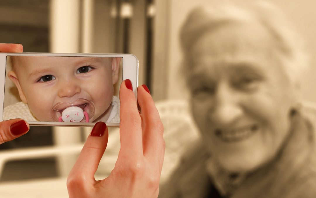 Picture showing on a baby on a cell phone and the reverse age of her older self for John R. Miles blog