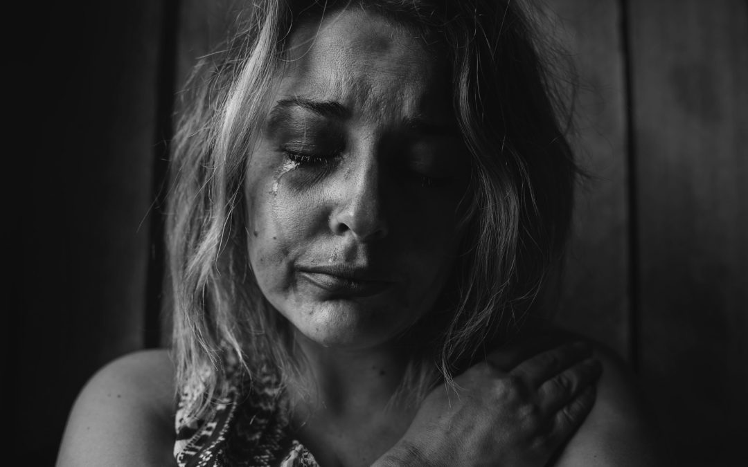 Black and white picture of a woman crying who is suffering from chronic loneliness