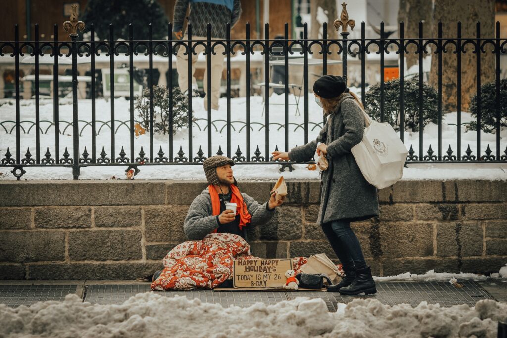 Woman displaying the holiday spirit to a homeless man