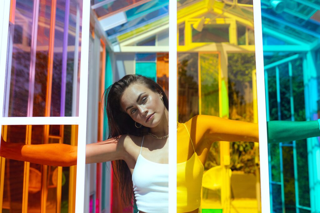A woman behind a rainbow wall showing her self-expression