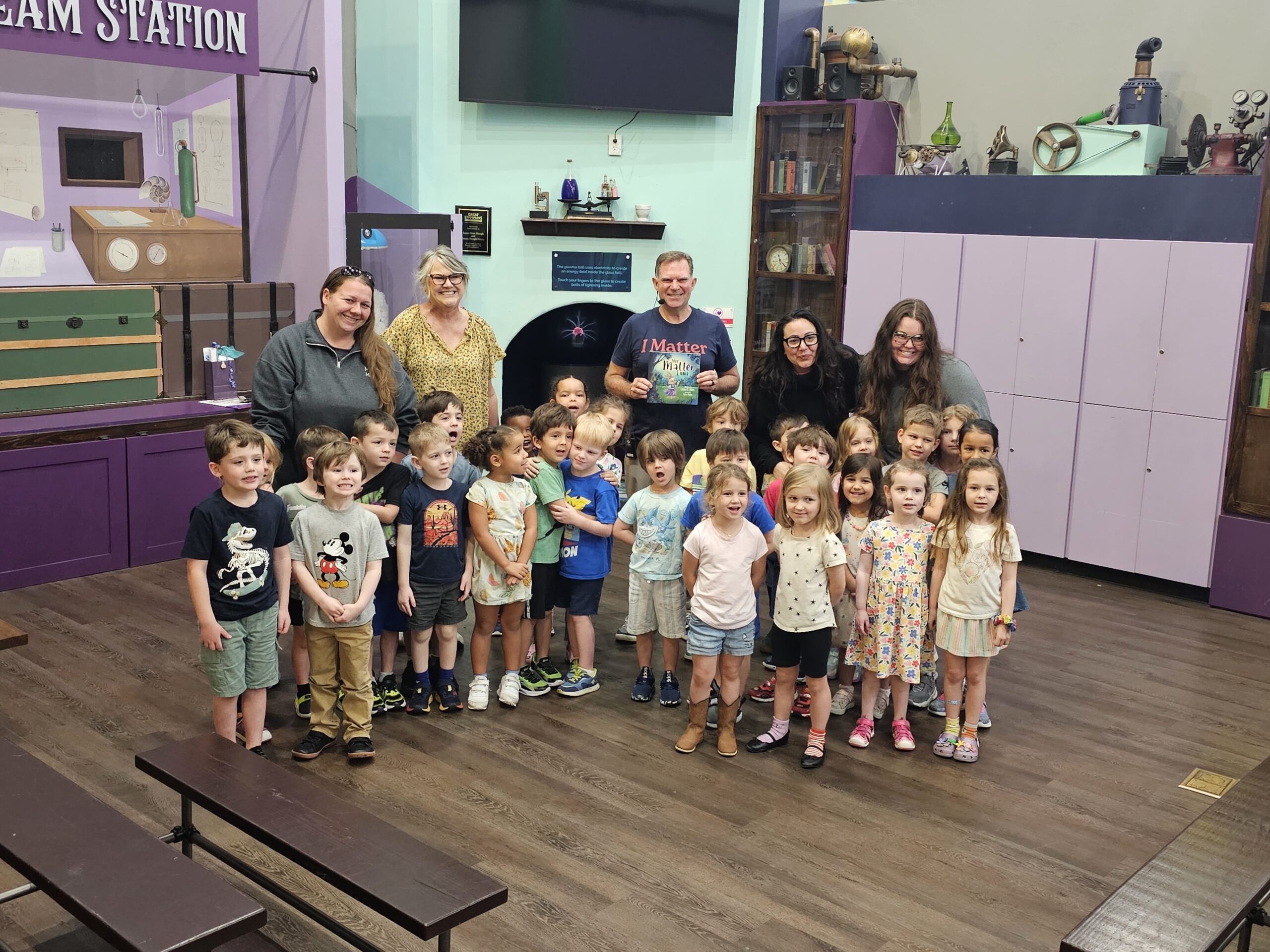 John R. Miles with children and educators at a community event supporting learning and belonging